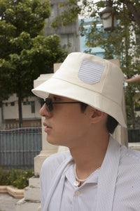 White cotton bucket hat with striped shirt pocket
