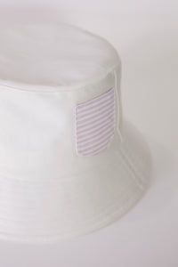 White cotton bucket hat with striped shirt pocket

