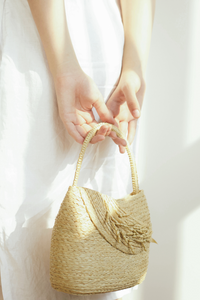 Lubéron is a handbag with short straps that are easy to grasp. It is constructed of raffia and has a bouquet of rice flowers connected to the body to add highlights. You can use the Lubéron bag as a night party accent or combine the two styles to be the party's focal point.

